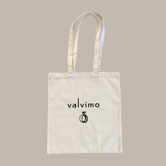 Luonnonvalkoinen kangaskassi pitkillä kantohihnoilla ja Valvimo-logolla.